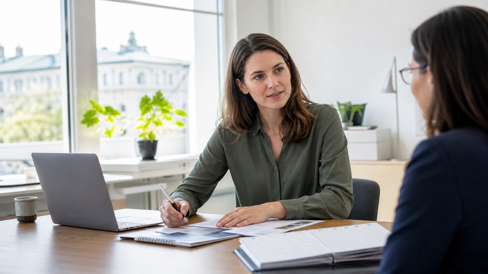 Beschäftigte plant Weiterbildung mit Unterlagen und Laptop in einem österreichischen Büro