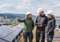 Fachkräfte besprechen eine Photovoltaik-Anlage auf einem begrünten Dach in Österreich